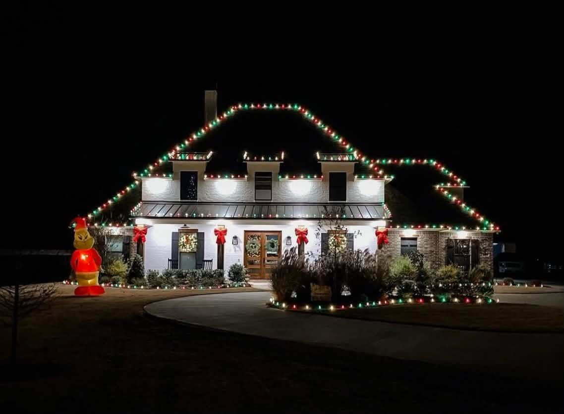 Professional Christmas light installation on a large home — red, green and warm white C9 LED roofline by Best Around Holiday Lights, Conroe TX